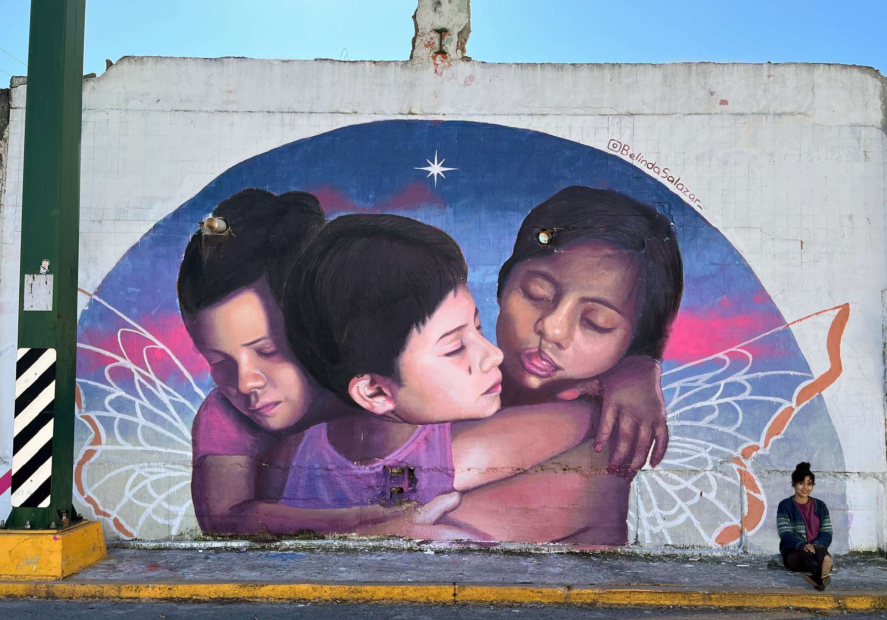 Mural de tres niñas abrazadas con alas de mariposa pintado por Belinda Salazar para el municipio de Guadalupe
