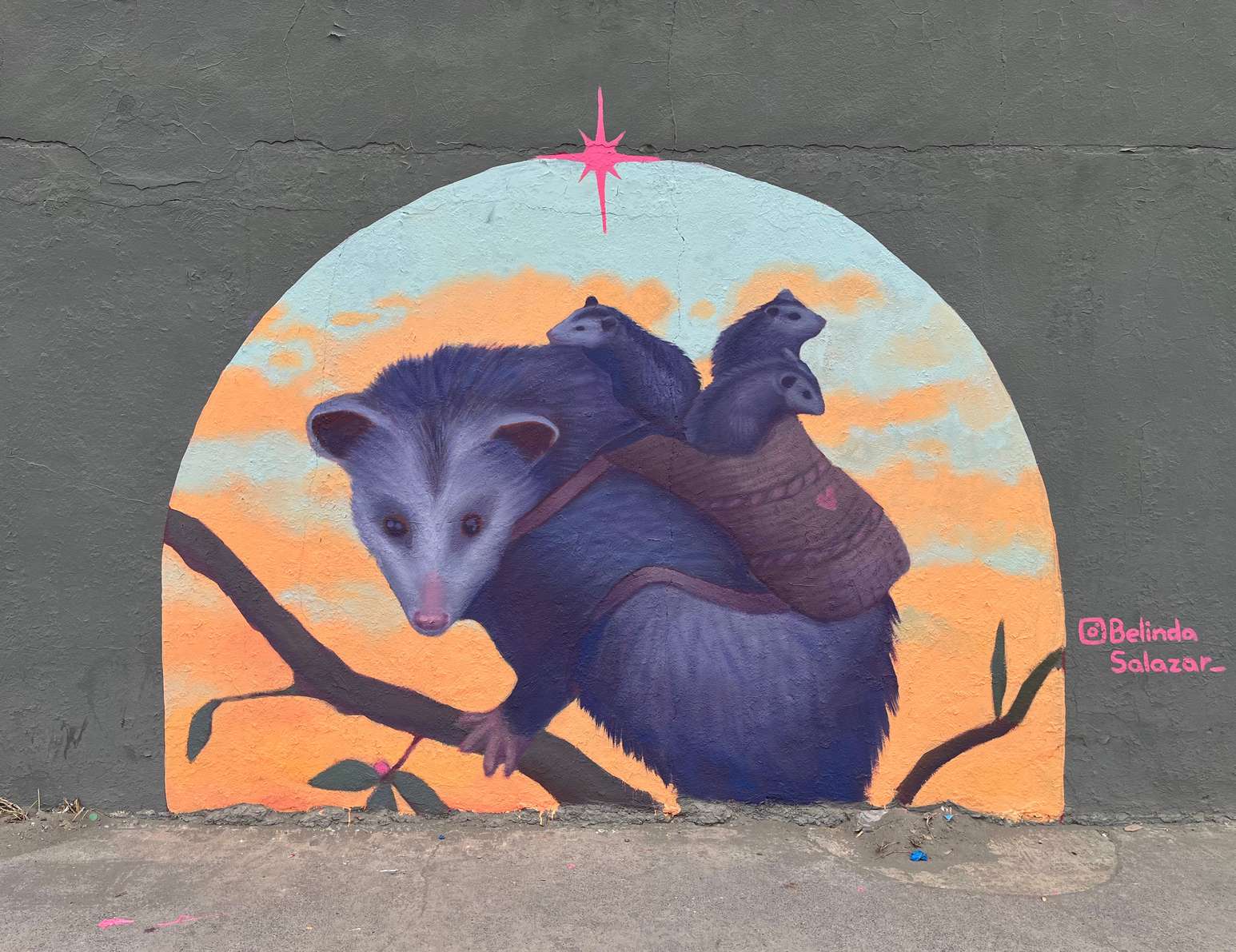 Mural de una mamá tlacuache cargando a sus crías pintado por Belinda Salazar para Ternium en San Nicolás de los Garza